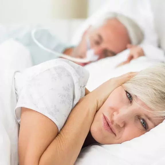 Casal na cama com CPAP